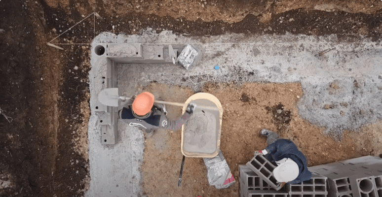 Sac de ciment FACILICIM posé sur un chantier extérieur, illustrant son emballage étanche et recyclable.