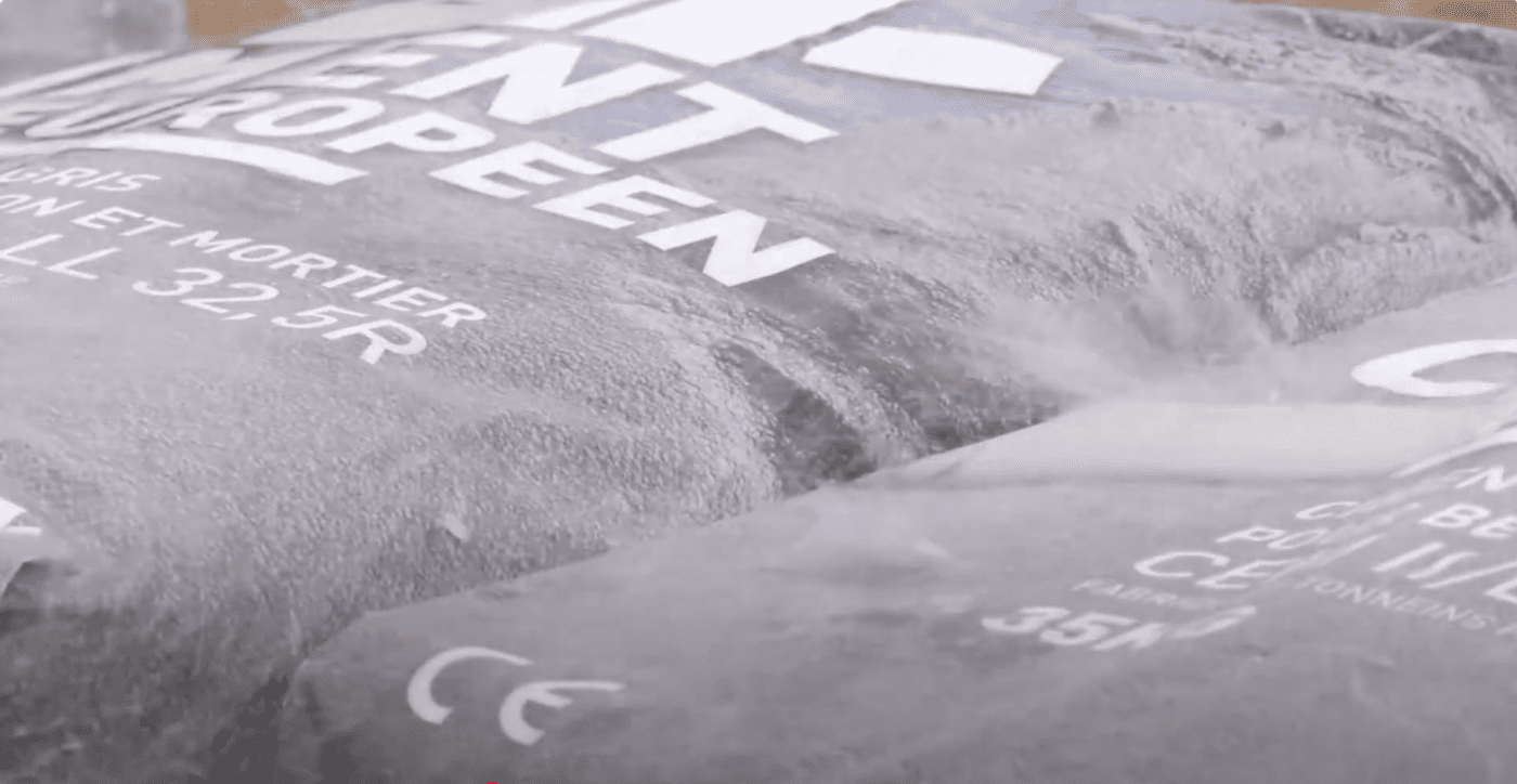 Sac de ciment FACILICIM posé sur un chantier extérieur, illustrant son emballage étanche et recyclable.